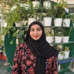 Expert science and Language Tutor – MyUstaza Online Learning Platform Professional South Asian female scienceteacher wearing a hijab, smiling confidently in front of plants — expert online tutor at MyUstaza.
