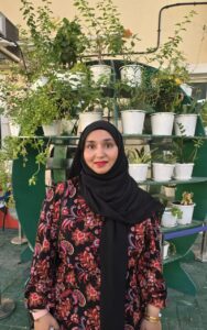 Expert science and Language Tutor – MyUstaza Online Learning Platform Professional South Asian female scienceteacher wearing a hijab, smiling confidently in front of plants — expert online tutor at MyUstaza.