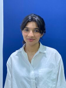 Professional South Asian female Prompt Engineering and coding teacher , smiling confidently in front of plants — expert online tutor at MyUstaza.