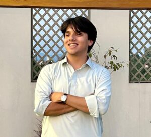 Professional South Asian male Mental Math teacher smiling confidently in front of plants — expert online tutor at MyUstaza.