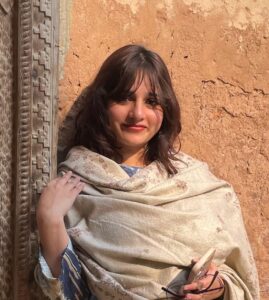 Expert Photoshop Language Tutor – MyUstaza Online Learning Platform Professional South Asian female Photoshop teacher smiling confidently in front of plants — expert online tutor at MyUstaza.