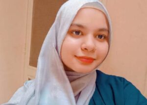 Professional female home tutor, history teacher and story teller wearing a hijab, smiling confidently in front of plants — expert online tutor at MyUstaza.